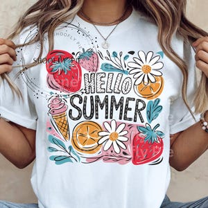 May include: White t-shirt with a colorful graphic design featuring strawberries, oranges, ice cream, and daisies. The text "Hello Summer" is printed in black.