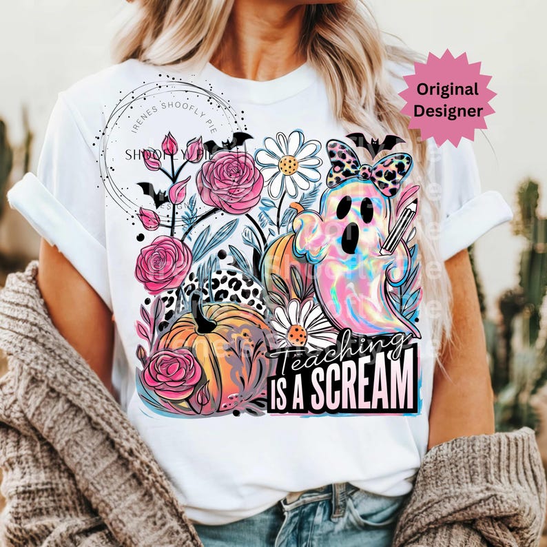 May include: White t-shirt featuring a colorful ghost holding a pencil, surrounded by flowers and pumpkins. The text "Teaching is a Scream" is displayed below the graphic. The design includes pink roses and a leopard print bow.