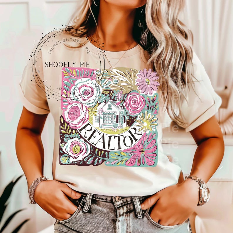 May include: A white t-shirt featuring a floral design and the word "REALTOR" in a green circle. The design also includes a small house.