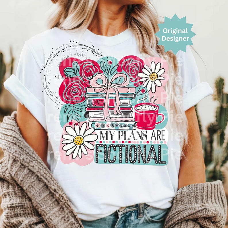 May include: White t-shirt featuring a colorful graphic with books, flowers, and a coffee cup. The text "MY PLANS ARE FICTIONAL" is displayed in a playful font. The design includes pink, teal, and black accents.