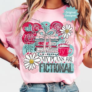 May include: Pink t-shirt with a graphic design featuring a stack of books tied with a pink bow, red roses, daisies, and a red coffee mug. The text "MY PLANS ARE FICTIONAL" is displayed below the books.