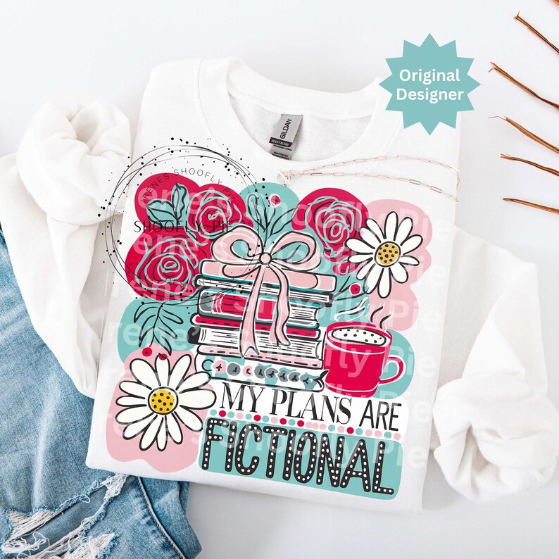 May include: White sweatshirt featuring a colorful graphic with books, roses, daisies, and a coffee cup. The text "MY PLANS ARE FICTIONAL" is displayed in a playful font. The design includes pink, red, teal, and white elements.