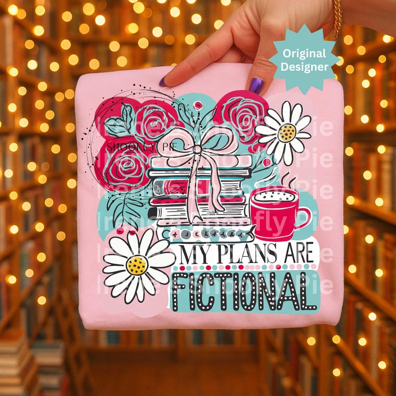 May include: Pink t-shirt with a graphic design featuring books, roses, daisies, and a coffee cup. The text "MY PLANS ARE FICTIONAL" is displayed in a teal font. The design includes a bow and the words "Original Designer".