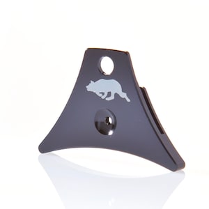 May include: Black whistle with a silver silhouette of a running dog on the front. The whistle has a round hole on the top and a smaller hole on the bottom.