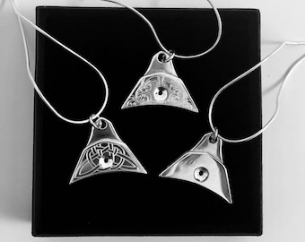May include: Three silver whistle pendants on black velvet chains. Each pendant is a different shape and has a decorative design.