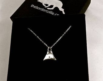 May include: A silver necklace with a whistle pendant in a black velvet box. The box has the text "thebordercollie.cc" printed on it.