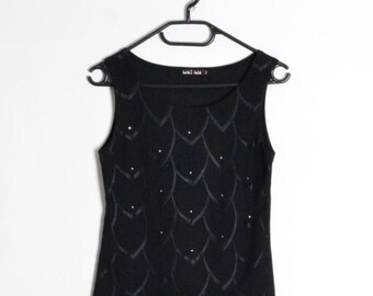 Op de afbeelding: Zwarte mouwloze top met een vierkante halslijn, versierd met een schubbenachtig patroon en kleine, sprankelende versieringen. De top hangt aan een zwarte hanger tegen een witte achtergrond en toont een eenvoudig, elegant ontwerp.