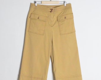 Op de afbeelding: Mosterdgele, wijd uitlopende cropped broek met een hoge taille en geribbelde tailleband, twee opgestikte voorzakken met knoopsluiting, een centrale ritssluiting en brede zomen aan de pijpen, vervaardigd uit een effen katoenen stof.