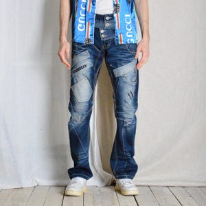 Op de afbeelding: Blauwe denim jeans met meerdere zakken en stiksels. De jeans hebben een ontspannen pasvorm en een rechte pijp.