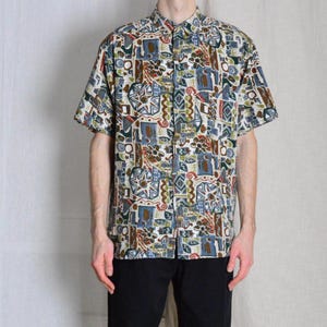 May include: A short-sleeved button-down shirt with a colourful geometric pattern in shades of blue, brown, green, and red.