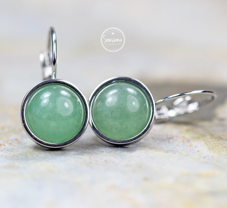 Peut inclure: Une paire de boucles d'oreilles en argent avec des cabochons de pierres pr&eacute;cieuses vertes. Les boucles d'oreilles ont un design simple et &eacute;l&eacute;gant et sont parfaites pour tous les jours.