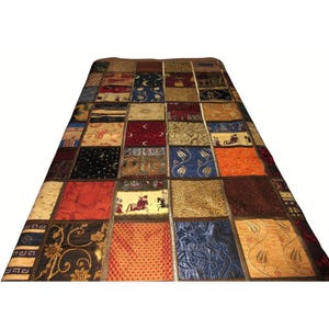 May include: A patchwork quilt with a variety of colors and patterns, including red, blue, gold, and brown. The quilt is made of different fabrics and textures, creating a unique and interesting design.