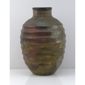May include: A ceramic vase with a rounded, ribbed body and a narrow neck. The surface features a mottled, metallic finish with blended tones of dark green, bronze, and deep purple, creating a textured appearance across the horizontal ridges.