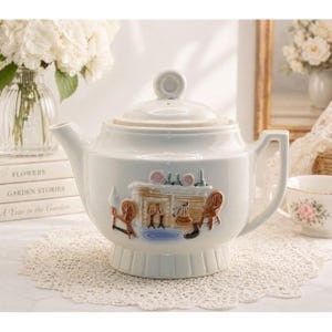 May include: A white ceramic teapot with a lid and handle. The teapot features a raised relief design of a cozy cottage scene with a fireplace, spinning wheel, and chairs. The teapot is sitting on a white lace doily.