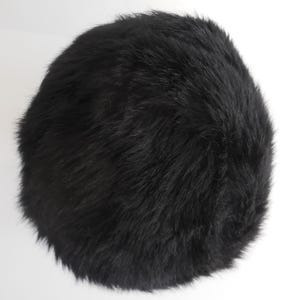 May include: A round, black fur hat. The hat is made of soft, dark fur and has a rounded shape. The hat is a solid black colour and appears to be a winter accessory.