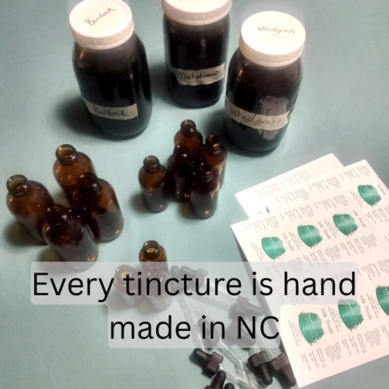 May include: An assortment of amber glass bottles and jars filled with dark liquid, labeled with handwritten names. The image includes the text "Every tincture is hand made in NC". Dropper bottles and printed labels are also visible.