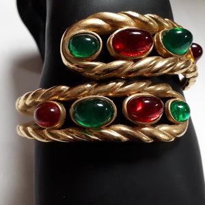 Puede incluir: Dos pulseras de tono dorado con un dise&ntilde;o de cuerda y piedras ovaladas rojas y verdes.