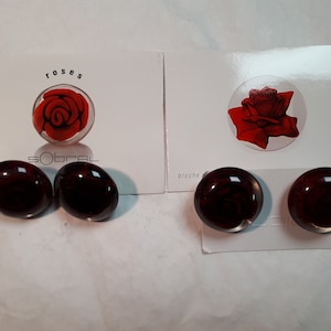 DEUX paires de boucles d'oreilles SOBRAL ROSES avec une étiquette d'origine et une notice, rouges et transparents, percées
