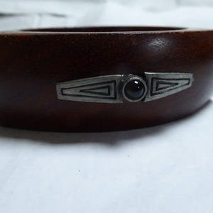 Bangle in palisander wood with art deco metal embellishments. Triangular shape