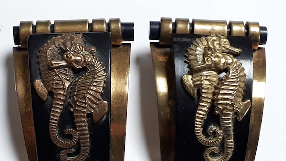 Art deco bakelite and metal dress clips, sea horses reminiscent of Jean Painlevé