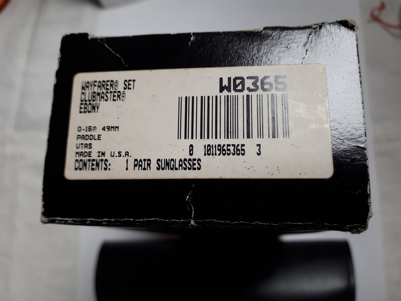 May include: Black cardboard box with a label that reads "WAYFARER SET CLUBMASTER EBONY." The label also includes "0-159 49MM" and "1 PAIR SUNGLASSES." The box has a barcode and the text "MADE IN U.S.A."