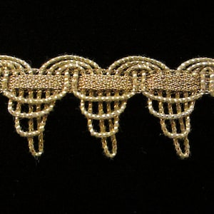 May include: Gold trim with a scalloped edge and a fringe detail. The trim is made of a woven metallic thread.