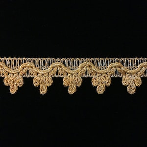 May include: Gold metallic trim with a scalloped edge. The trim has a delicate, intricate design.