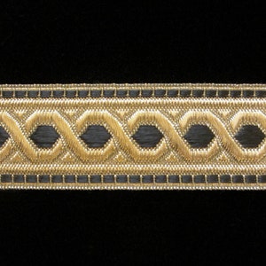 May include: Black and gold trim with a repeating pattern of interlocking circles and ovals. The trim is made of woven fabric and has a subtle sheen.