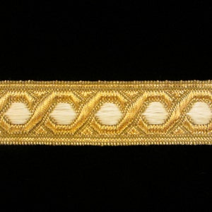 May include: Gold trim with a repeating pattern of white oval shapes. The trim is woven with a subtle texture.