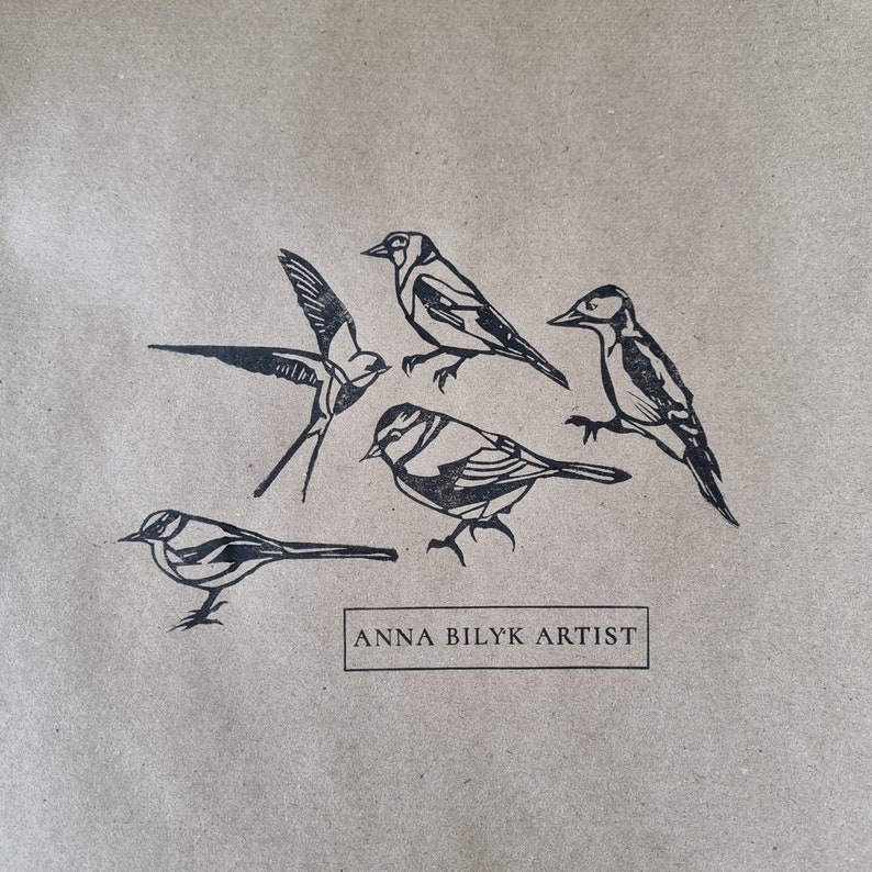 Five hand printed images of the rubber lino stamps on brown kraft paper, included are the Swallow, Goldfinch, Grey Wagtail, Blue Tit and a Woodpecker. Artists logo stamp is also included reading Anna Bilyk Artist.
