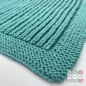 May include: A close-up of a teal knitted fabric with a ribbed texture. The fabric has a border around the edge.