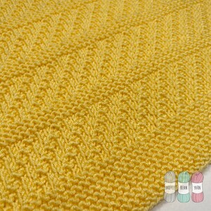 May include: A close-up of a yellow knitted fabric with a textured pattern. The fabric is soft and has a subtle sheen.