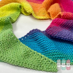 May include: A rainbow colored crocheted scarf with a green, blue, purple, pink, orange, and yellow color gradient. The scarf is made with a knit stitch and is laying on a white surface.