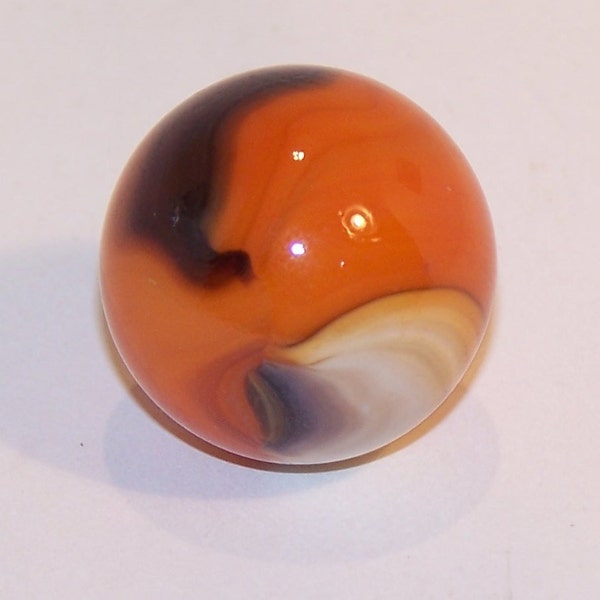 Glass Marble with orange base, black, green, and white streaks