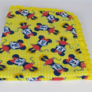Pu&ograve; includere: Coperta per neonati in pile giallo con stampa di Topolino e bordo all'uncinetto giallo.