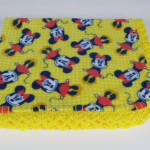 Pu&ograve; includere: Coperta per neonati in pile giallo con stampa Mickey Mouse e bordo all'uncinetto giallo.