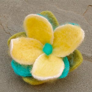 May include: A yellow felt flower with a turquoise center, surrounded by green felt leaves.