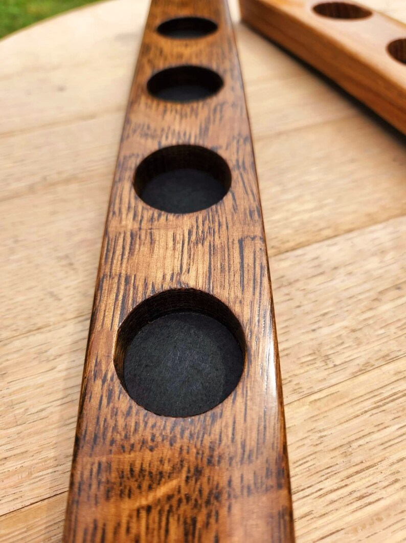 May include: A wooden coaster with four circular cutouts, ideal for holding glasses or mugs. The coaster is made from reclaimed wood and has a natural, rustic finish.