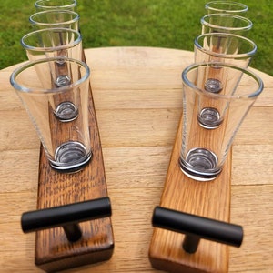 May include: Two wooden shot glass holders with black handles. Each holder has four shot glasses.