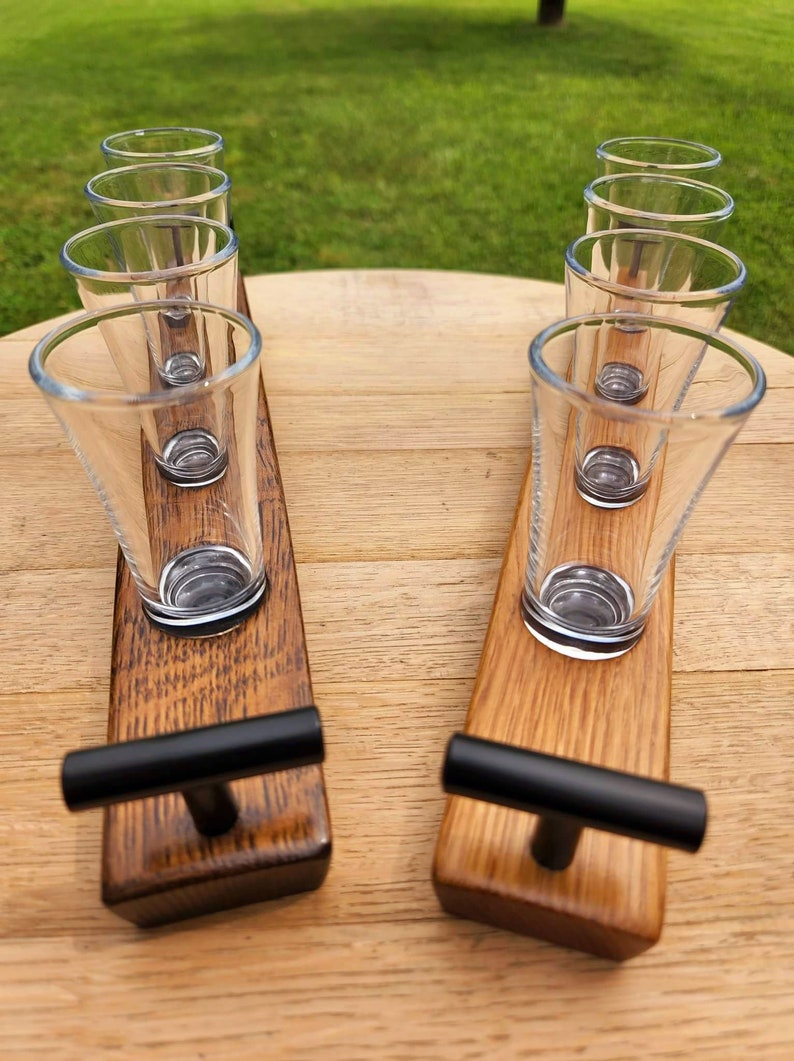 May include: Two wooden shot glass holders with black handles. Each holder has four shot glasses.