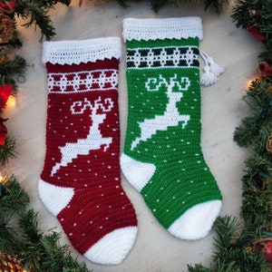 May include: Two crocheted Christmas stockings with white reindeer designs. One stocking is red with white trim and the other is green with white trim.