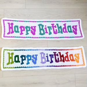 May include: Two crocheted banners with the words "Happy Birthday" in colorful yarn. The top banner has pink, purple, and green yarn, while the bottom banner has a rainbow of colors.