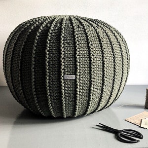 Pode incluir: Um grande otomano redondo de malha verde com uma etiqueta que diz "Zuri".