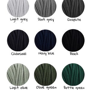 May include: Nine balls of yarn in different colors: light grey, dark grey, graphite, charcoal, navy blue, black, light olive, olive green, and bottle green.