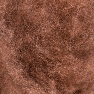 K&ouml;nnte beinhalten: Nahaufnahme eines braunen, flauschigen Materials. Die Textur ist weich und scheint aus Naturfasern zu bestehen.