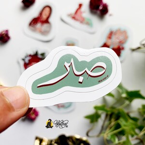 May include: A green and red sticker with Arabic calligraphy that says "Sabah" which means "Morning" in Arabic.