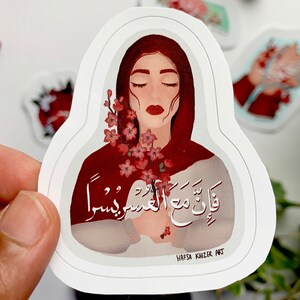 May include: A sticker featuring a woman with closed eyes holding a bouquet of pink flowers. The woman is wearing a red headscarf and the background is white. The sticker has the text "قَالَتْ مَعَ الْعَسِيرِ يَسِيرُ" in Arabic script and the text "HAFSA KHIZER ART" in black text.