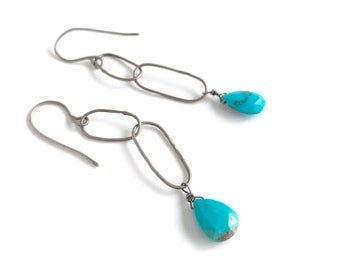 Faceted turquoise teardrops hung from sterling silver hoops . All handmade earrings.
