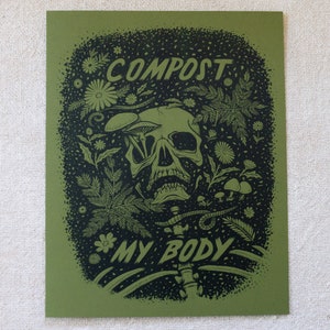May include: A green and black print with a skull surrounded by plants and mushrooms. The text "COMPOST MY BODY" is printed below the skull.