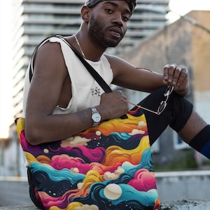 Może przedstawiać: Kolorowa torba typu tote z wzorem wirujących chmur i fal w odcieniach różowego, niebieskiego, żółtego i pomarańczowego. Torba ma czarne tło i biały księżyc.